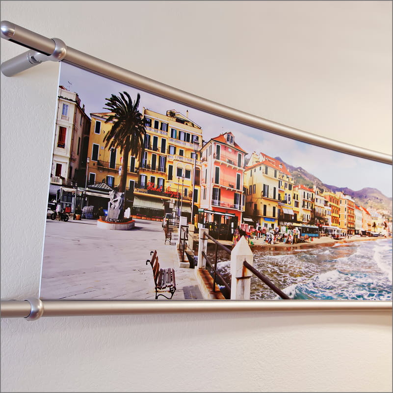 Panoramic wall art mounted horizontally using a silver rod and clamp system.