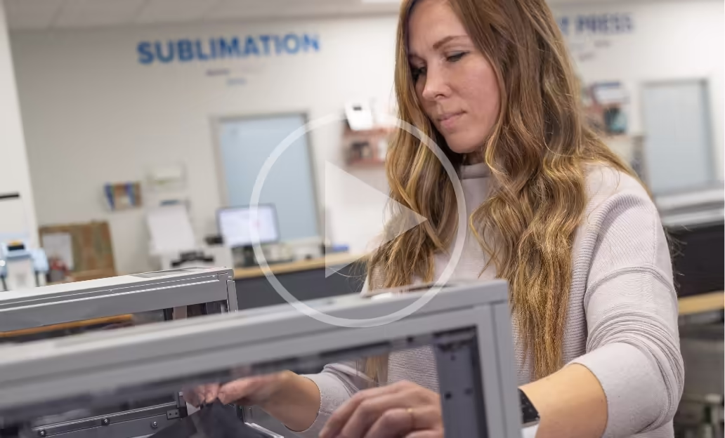 Technician demonstrating sublimation printer setup in a workshop