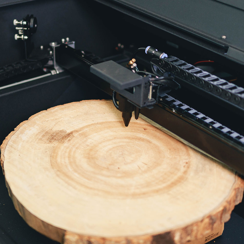 Beambox II laser engraving on a wood round