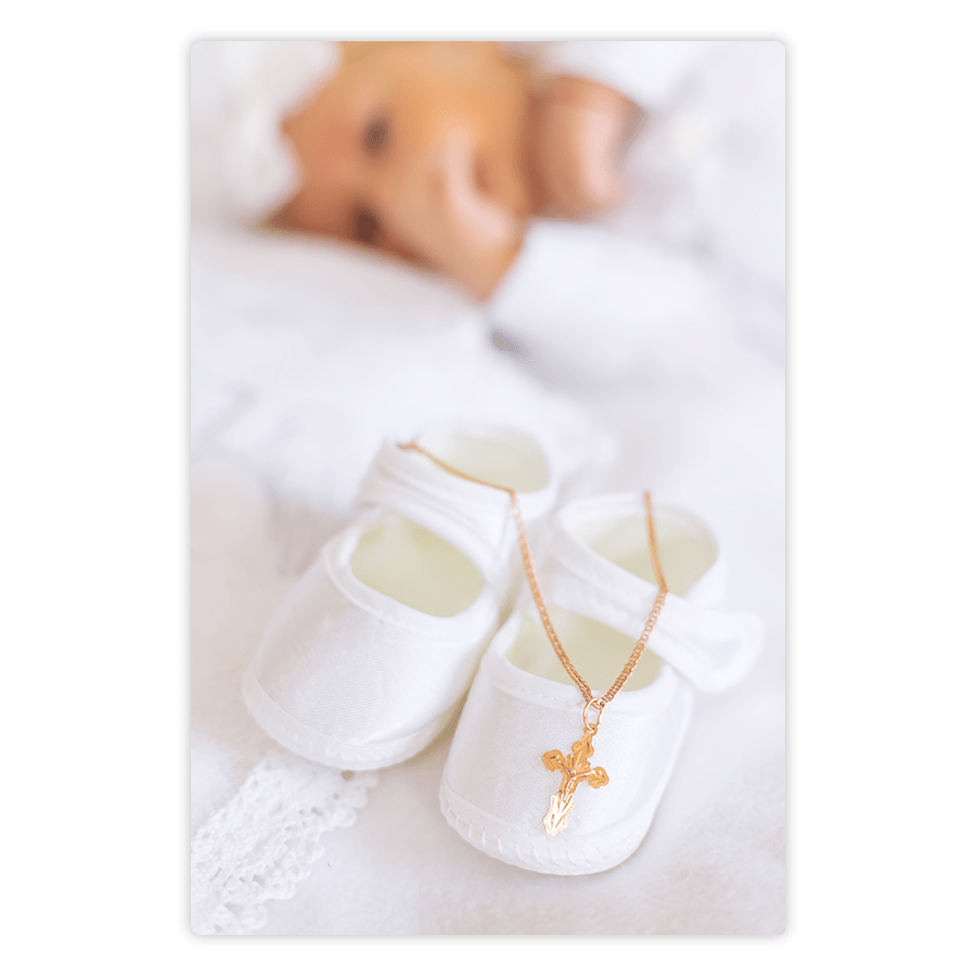 Baby shoes and cross necklace on aluminum easel frame