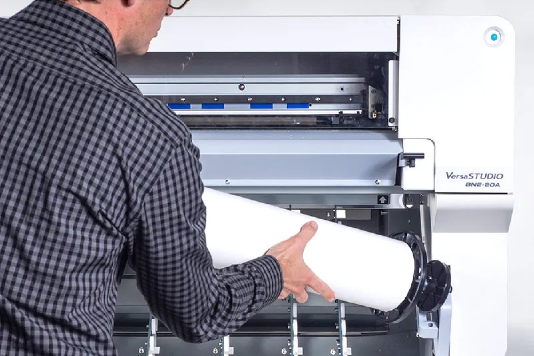 Man loading roll paper in the Roland BN2-20A