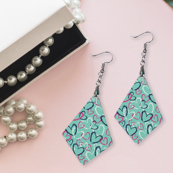 Sublimation earrings next to pearl necklace