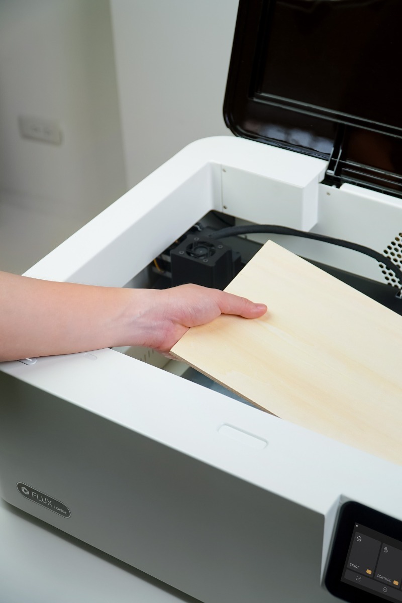 Placing wood into Flux Ador engraver