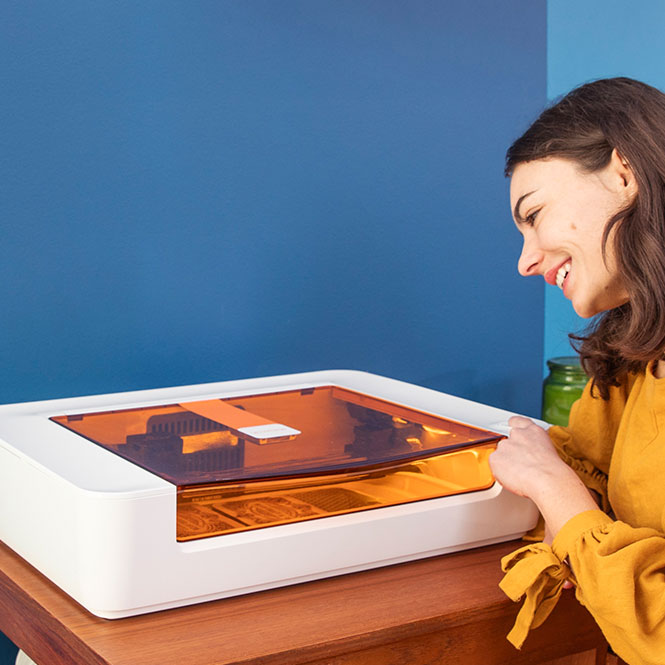Glowforge Spark diode laser on desk with woman