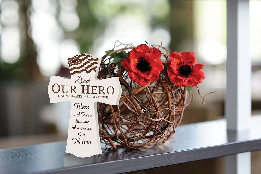 White engraved cross by flowers