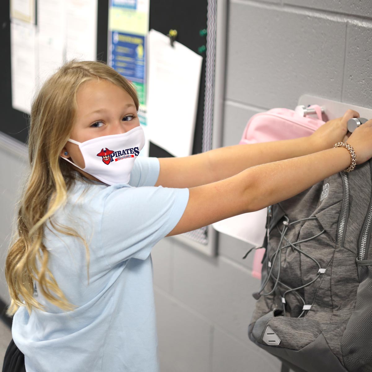Girl hanging backpack wearing face mask
