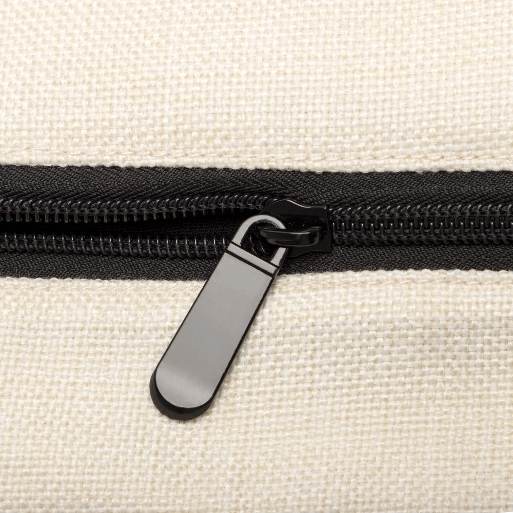 A close-up of a black zipper with a black pull tab on a cream-colored linen fabric background. 