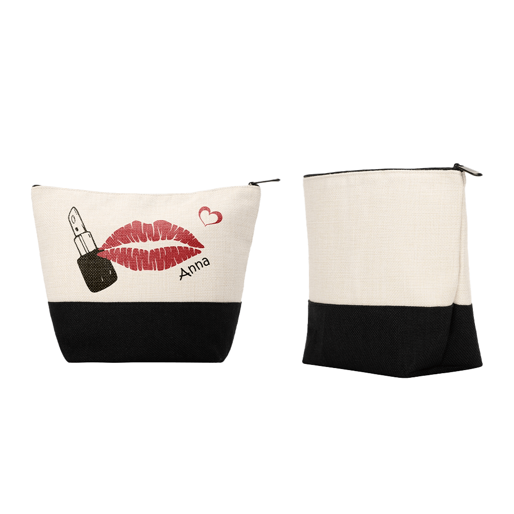 Two small linen makeup bags, one with a red lipstick kiss print and the name 'Anna' embroidered, the other plain and zipped closed. Both with black bottoms and beige tops.