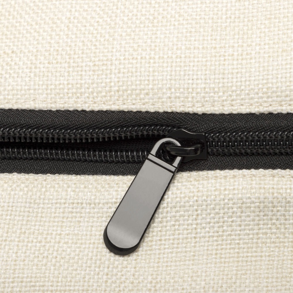 Close-up of a black zipper on a cream-colored linen fabric background.