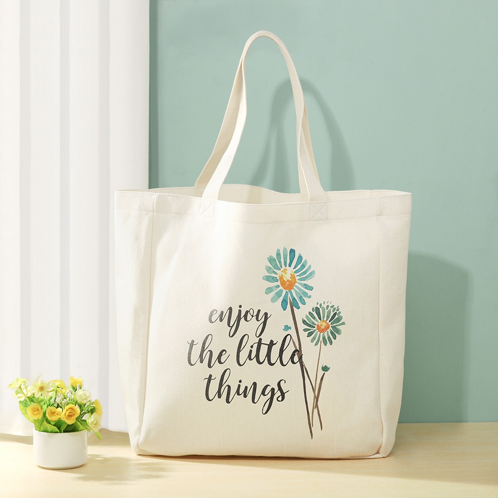 Linen tote bag with floral design on table with flowers