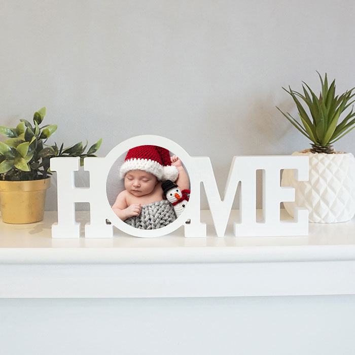 personalized White Coated Wood Block That says HOME on a shelf with some plants