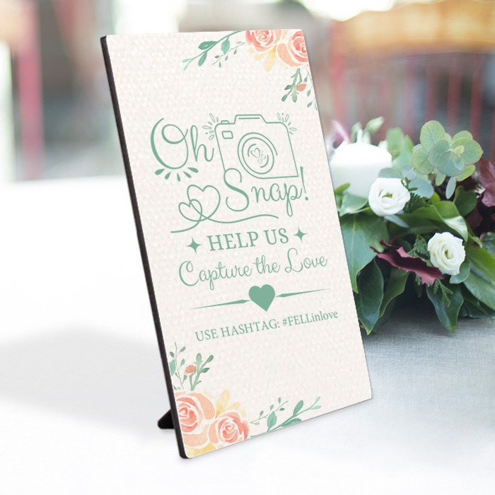 Photo panel with wedding hashtag message on table
