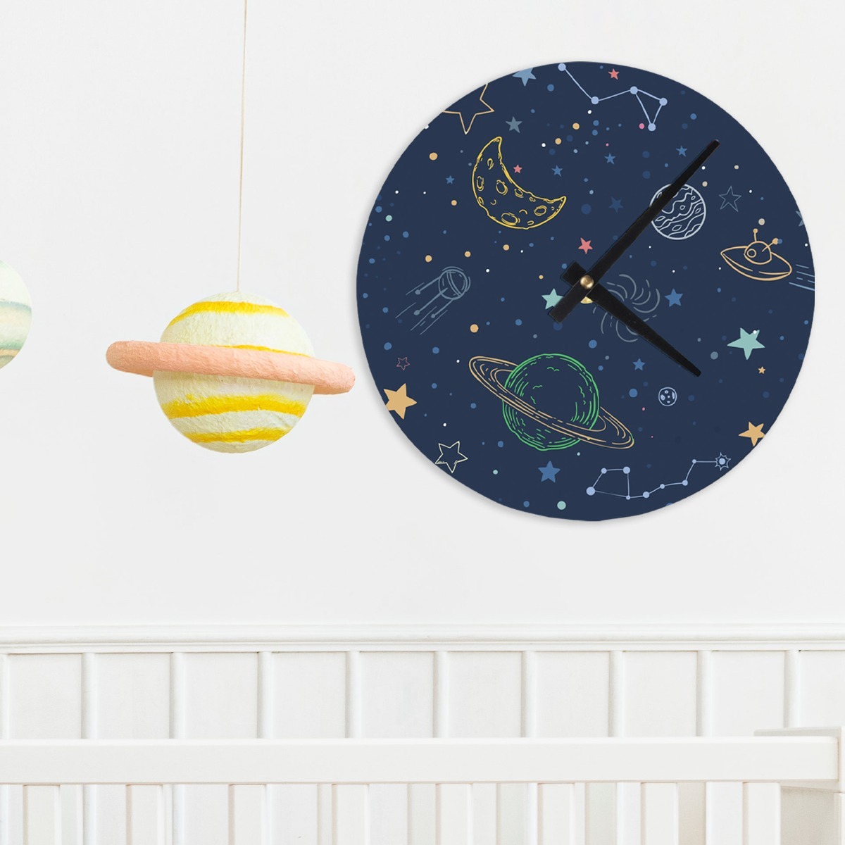 Clock with space design hanging over crib