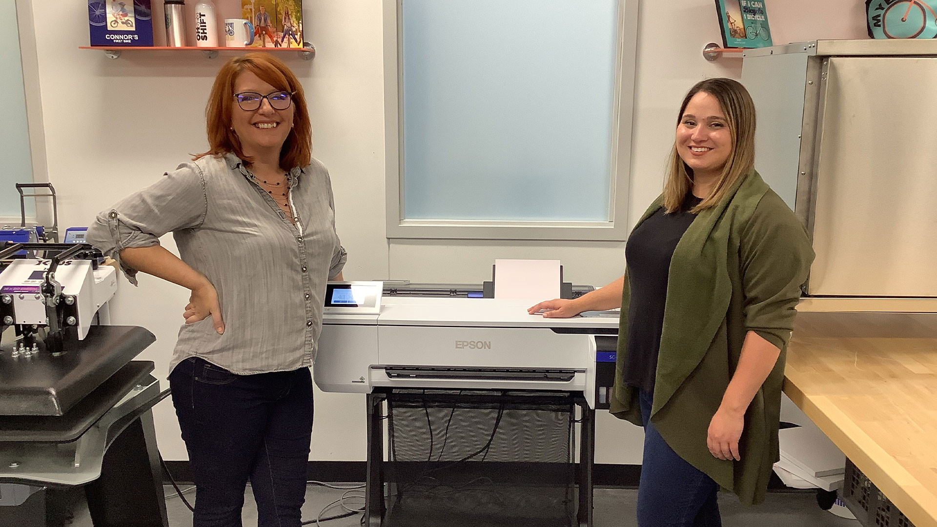 Two women flanking a printer