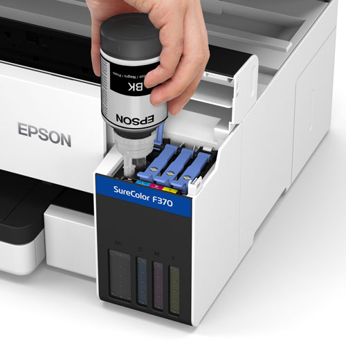 image of the Epson SureColor F370 printer with ink cartridge lid open and a hand holding black Epson ink filling the tank